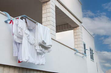 Clean white laundry drying on the balcony, warm sunny day