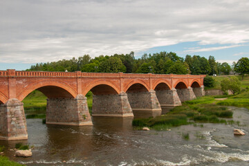 Latvia, City of Kuldiga - the ancient bridge crosses the Vetna River, a few meters from the waterfalls. The calling card of the city.