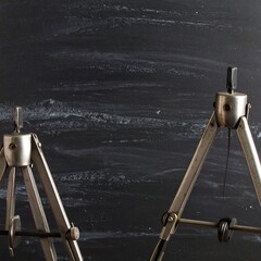 Vintage metal tripods against a dark chalkboard