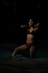 Fototapeta premium Mid Shot Portrait of Woman Wearing Bikini Relaxing by Poolside 