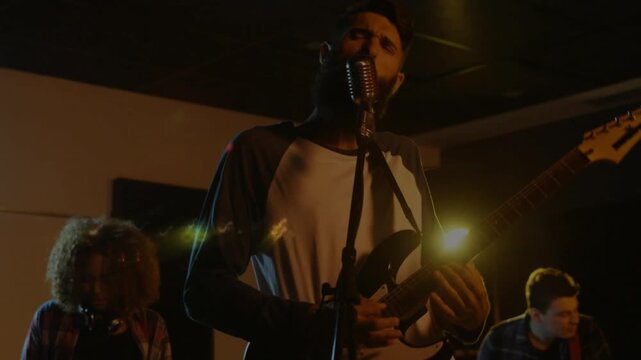 Singer leaning into mic and singing, causing animated lens flares sweeping over band performance