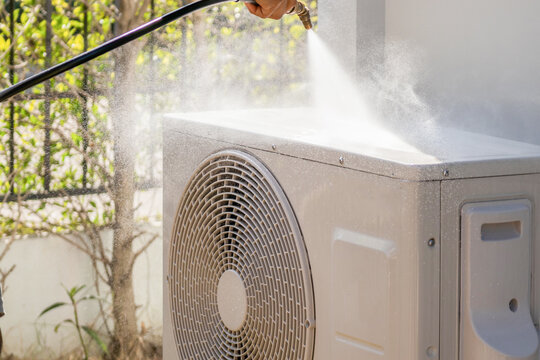 air conditioning compressor outdoor unit cleaning service with water spray - Powered by Adobe