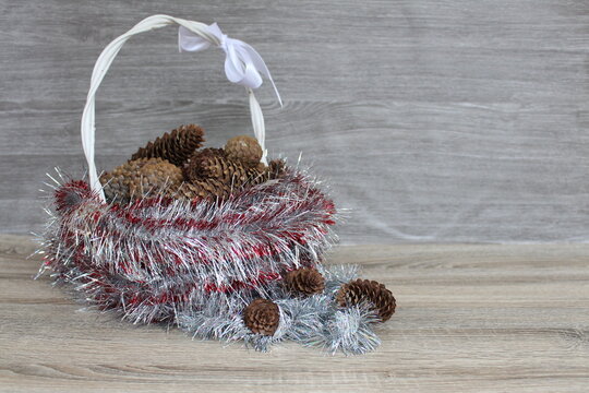 pine cones in a basket on a wooden table - Powered by Adobe