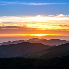 Fototapeta premium Sunset over rolling hills, coastal view
