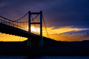 Landscape view of Suspension bridge building with car driving over Jokulsarlon glacier lagoon with sunset skyline in autumn season Iceland