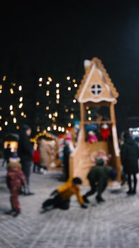 Winter children's fun, roller coaster ride in the city square at night, blurred