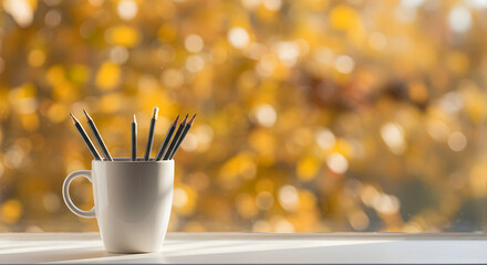 Autumnal inspiration: pencils in a cup with golden bokeh for creative pursuits and fall season aesthetics on the