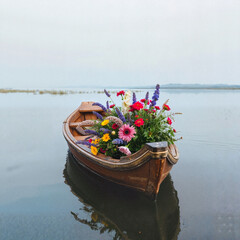 Flower-filled boat floating on a calm lake, serene atmosphere, copy space