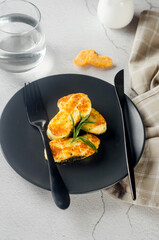 Pieces of fried halloumi on a plate and tomatoes. Balanced and healthy food.