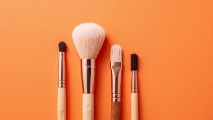 Makeup brushes set with natural bristles and wooden handles on an orange background.