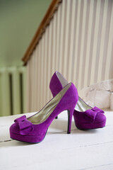 Purple high heels on a white floor background