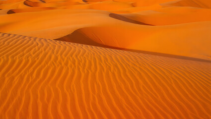 Vibrant Orange Desert Dunes: Textured Sand Landscape at Sunset, Warm and Serene.
