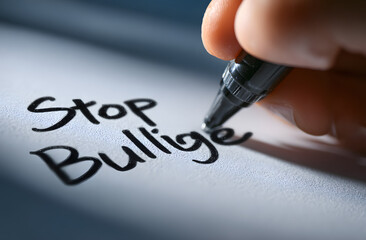 Hand with marker writing the word Stop Bullying