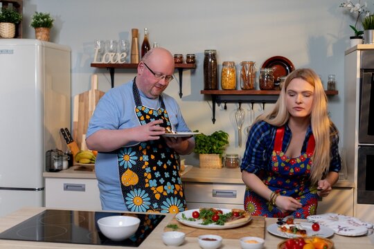 A Culinary Duo Skillfully Preparing Fresh Ingredients Together in a Modern Kitchen Setting