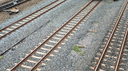 Fototapeta premium Train track or railroad with steel rail structure and gravel rock ground, Top view. Transportation infrastructure for background and texture.