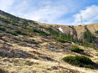 Obraz premium View of an alpine mountain range with remnants of snow against the sky in spring.