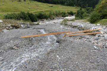 Rockslide in river with broken wooden riverbank