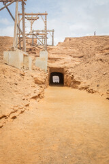 Colorful daytime photograph of traditional salt flats on Sal Island, Cape Verde. Outdoor landscape showcasing vibrant salt pans and distant silhouettes of unidentified people in the background. Captur