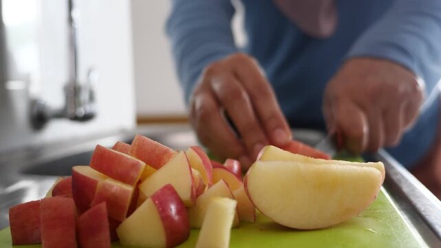 Asian muslim woman cutting slicing apple and pear fruits in kitchen