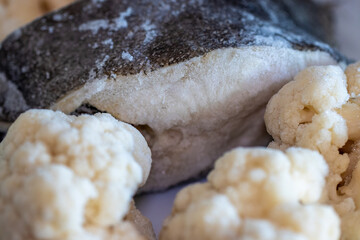Frozen cauliflower and halibut, healthy food stored in the refrigerator and ready to eat.