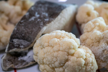 Frozen cauliflower and halibut, healthy food stored in the refrigerator and ready to eat.
