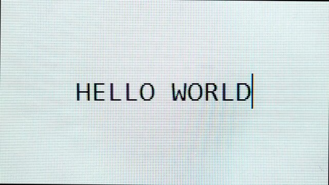 Word "HELLO WORLD" is typing and erased on pixel-style screen.