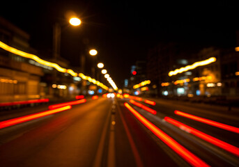 Fototapeta premium Blurred city lights streak illuminating night scene with vibrant red and yellow creating abstract urban motion