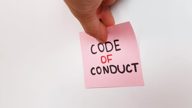 CODE OF CONDUCT text, inscription on a note on a white wall. Code of conduct, rules and principles of behavior.