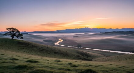 Fototapeta premium Picturesque landscape featuring a river winding through misty hills at sunrise