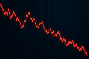 A sharply declining red line graph against a dark grid evokes a sense of financial market downturn.