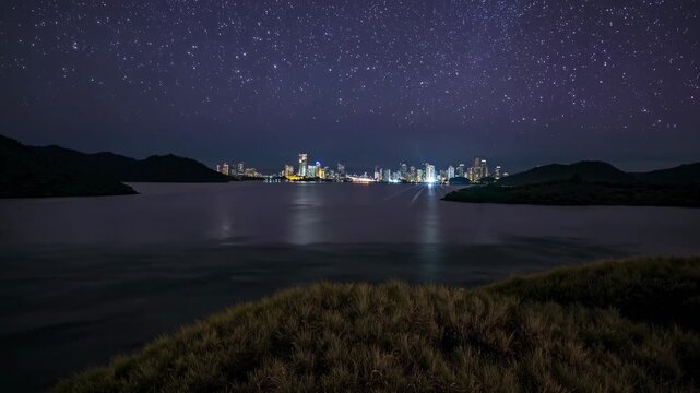 Stunning City Skyline Transitioning From Sunset to Night With Stars Illuminating the Sky Over a Serene Waterfront Landscape