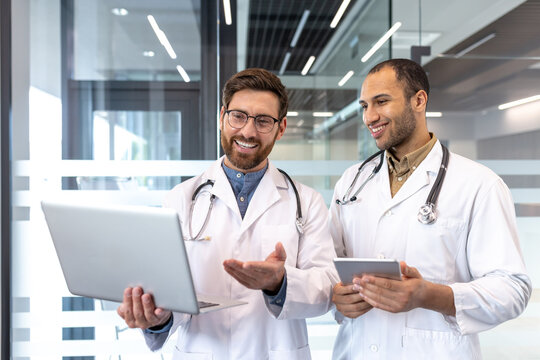 Two Doctors Collaborate Using Technology in a Modern Hospital Office - Powered by Adobe