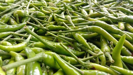 A close-up of green chilies, highlighting their fresh green color and smooth texture. Fresh agricultural produce. High Angle.