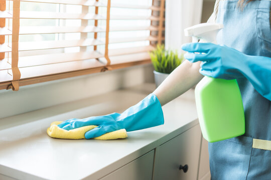 Cleanliness, asian young woman work chore cleaning on cupboard at home, hand wearing glove using wiping cloth remove dust with spray bottle. Household hygiene clean up, equipment tool for cleaning