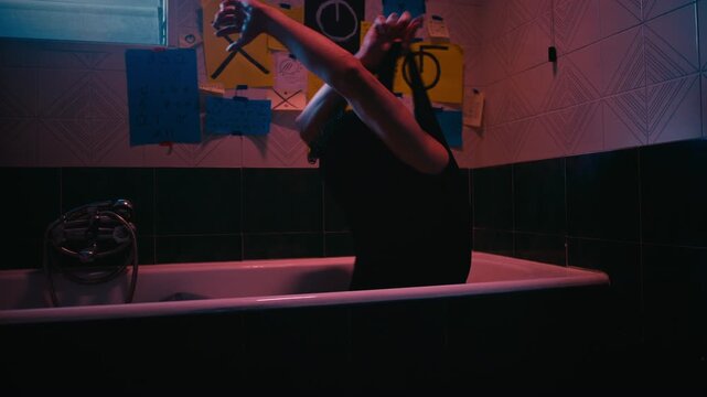 Depressed Man Taking Off His Clothes In The Empty Bathub