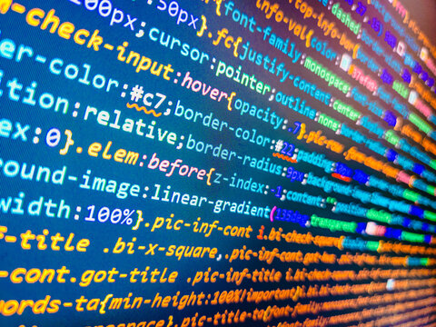 Program development concept. Programming code abstract screen. Developer working on program codes in office. Minificated web development javascript code close up in sunset rays