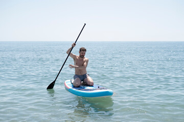 Tourist enjoying stand up paddle boarding on a sunny day