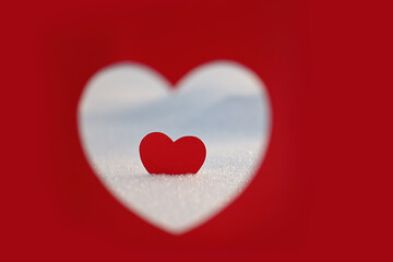 Happy Valentine's Day celebration. The concept of love in the form of a heart. Postcard dated February 14th, red heart in the snow, a place for the text. Winter holidays. Paper red heart.