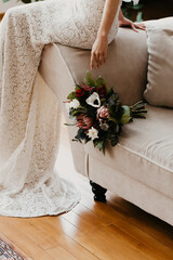 Bride Sitting on Sofa with Elegant Wedding Bouquet