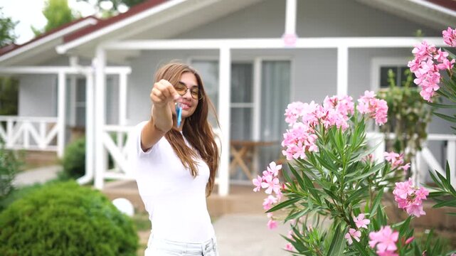 The concept of buying real estate with Dom Capital, a beautiful girl in glasses happy to buy a new house keys to the house dacha