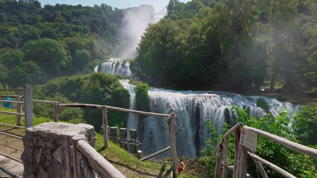 Ascending movement shot of Marmore Waterfall, scenic summer view with powerful cascade and surrounding forest