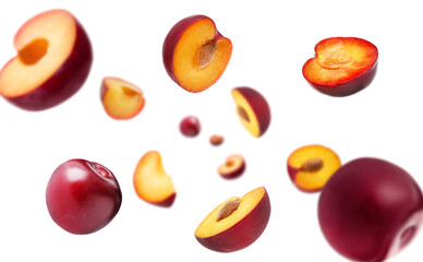Fresh ripe plums swirling in air against white background