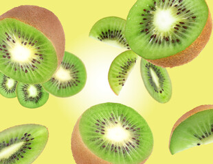 Fototapeta premium Cut fresh kiwi fruits swirling in air against yellow gradient background