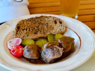 German meatballs with bread and pickles on a plate ready to eat with beer