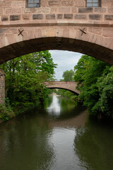 Fototapeta premium Hallertor Bridge (Hallertorbrucke) an arch bridge over the Pegnitz River on Nuremberg's Old Town's west side viewed from Kettensteg pedestrian bridge
