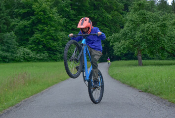 Boy doing a wheelie on a BMX bike outdoors in Switzerland