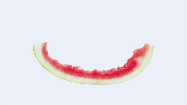 Slow motion footage of biting into a piece of watermelon in reverse on white background.