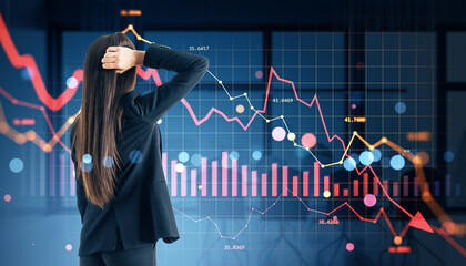 Worried businesswoman watching global financial market crash with red downward graphs and stock price collapse on digital screen background.