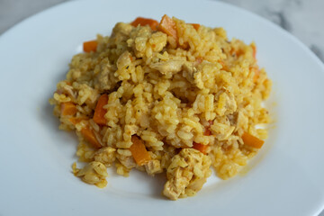 A close-up of finished Plov, showing the fluffy golden rice grains, tender chunks of chicken, and soft orange carrots. This detailed shot captures the final dish, ready to be served, making it ideal f