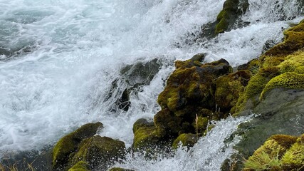 Close-up of Waterfall Splashing on Mossy Rocks in Iceland